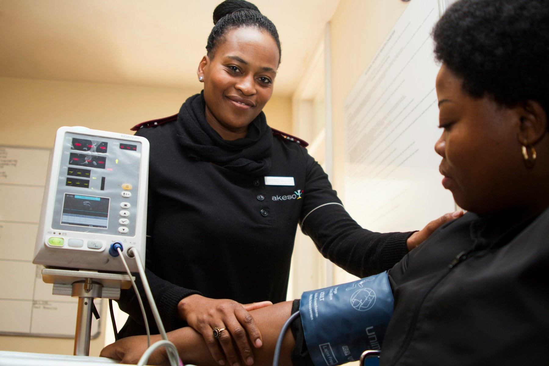 Nurse supporting an older adult during a mobility and blood pressure check